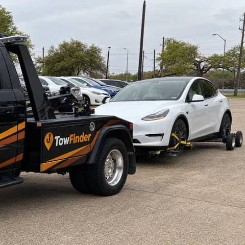 TowFinder wheel-lift tow truck with wheel dollies towing a white electric SUV in Detroit