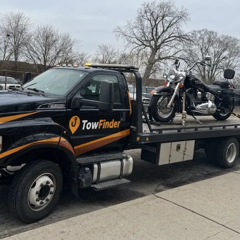 Motorcycle strapped down on a TowFinder flatbed tow truck